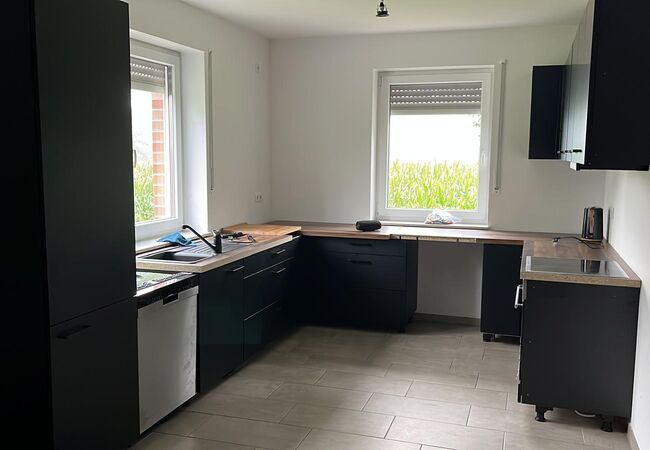 fertig aufgebaute Küche mit dunklem Corpus und Hängeschränken